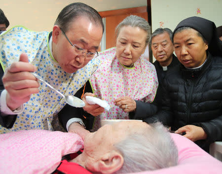 Former U.N. secretary-general Ban Ki-moon feeds a elderly woman at a social welfare facility in Eumseong, South Korea, January 14, 2017. Kim Do-hoon/Yonhap via REUTERS