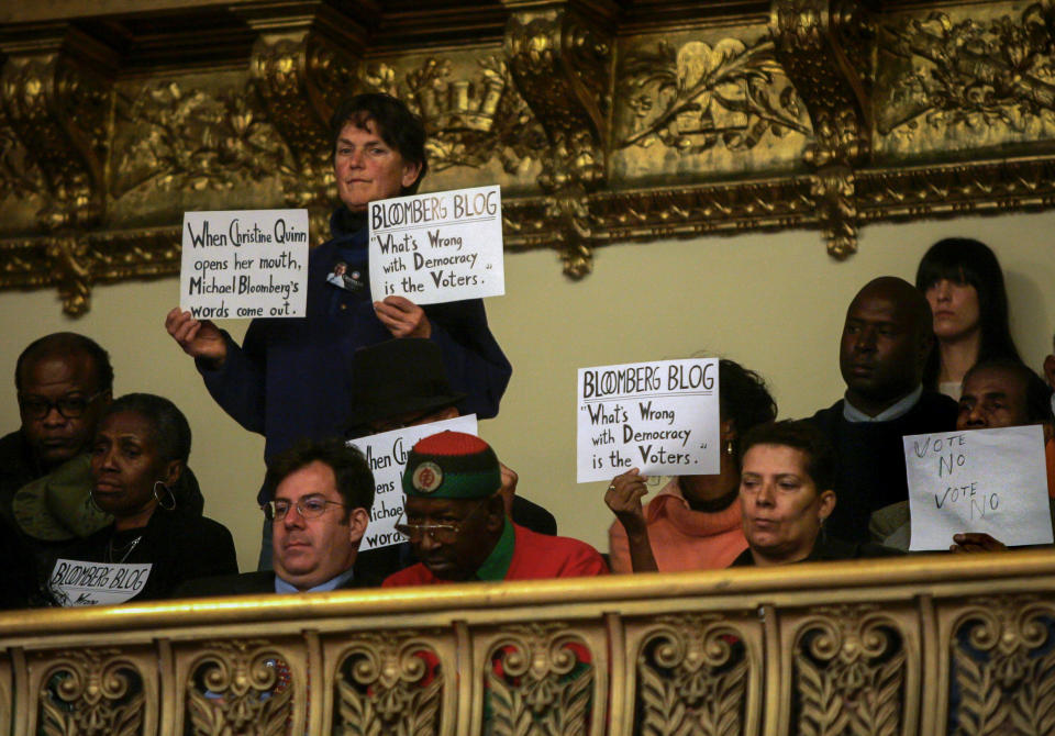 File-This photo from Thursday Oct. 23, 2008, shows protestors with against changing term limits, during a debate on term limits at City Hall in New York. Bloomberg won a third term in office after engineering a term-limits-law change from two to three four-year terms. (AP Photo/Frank Franklin II, File)