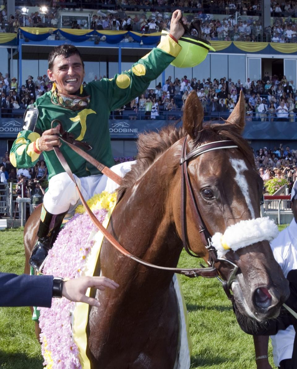 FILE - Eurico Rosa da Silva celebrates after winning the 151st Queen's Plate aboard Big Red Mike at Woodbine Racetrack on July 4, 2010, in Toronto. On the track, the jockey in his early 30s was winning races and making money. At home, he fought suicidal thoughts every day. Da Silva got help in 2006 and rode for more than a decade before retiring. (Frank Gunn/The Canadian Press via AP, File)