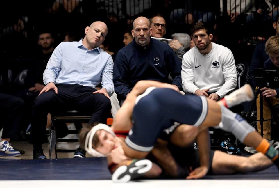 Penn State wrestling coach Cael Sanderson, next to assistants Casey Cunningham and Jimmy Kennedy, watch Carter Starocci during the match against Indiana on Sunday, Jan. 14, 2024 at Rec Hall.