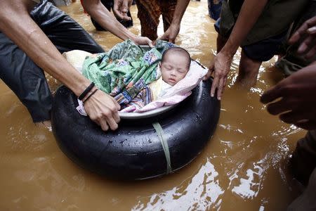 Residents evacuates a two-week old baby from a flooded area in east Jakarta in this February 4, 2007 file photo. REUTERS/Enny Nuraheni/Files