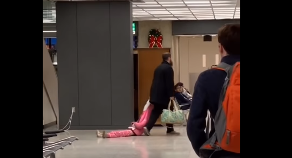 A young girl being dragged through Dulles International Airport by her dad, as captured on video New Year’s Day. (Photo: JF_112 via Reddit)