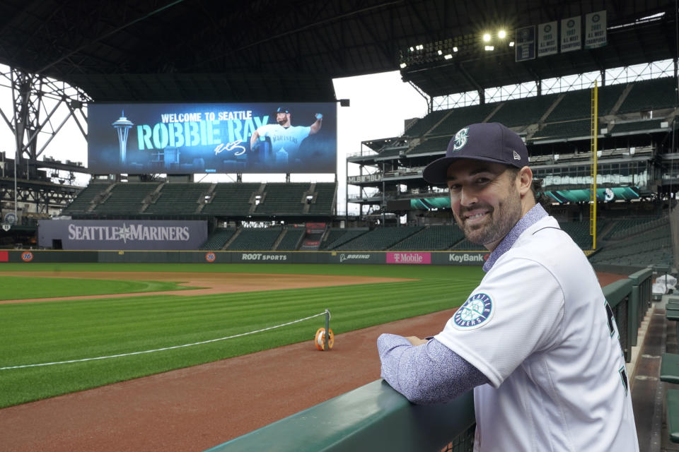 Seattle Mariners pitcher Robbie Ray poses for a photo in the dugout at T-Mobile Park, Wednesday, Dec. 1, 2021, following a news conference in Seattle. The AL Cy Young Award winner — who previously pitched for the Toronto Blue Jays — signed a five-year contract with the Mariners. (AP Photo/Ted S. Warren)