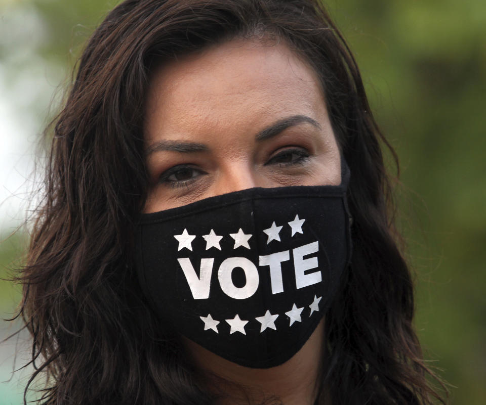 Beatrice Gonzalez wears her face mask as she waits in line to early vote at McAllen Fireman's Park during early voting for the general election, Tuesday, Oct. 13,2020 in McAllen, Texas. (Delcia Lopez/The Monitor via AP)