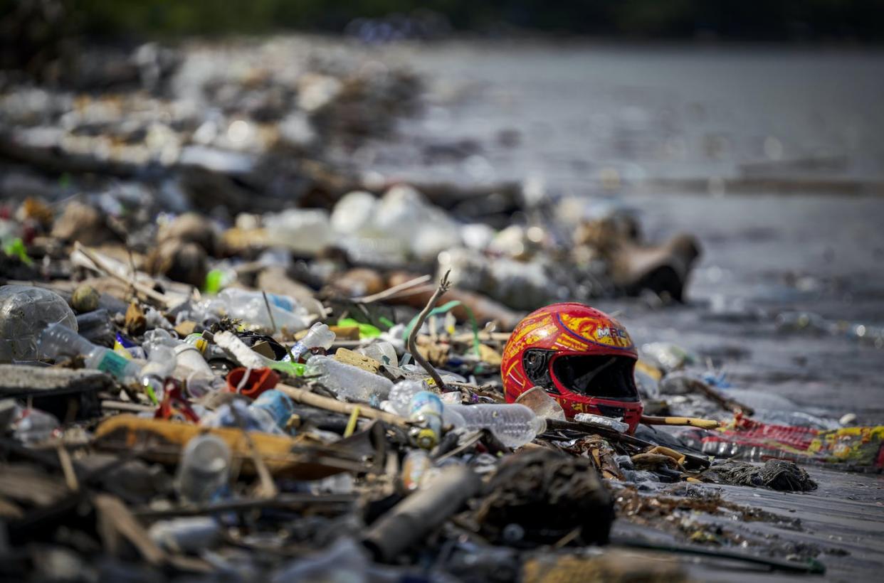 Plastic litters a beach in Manila, Philippines. <a href="https://www.gettyimages.com/detail/news-photo/motorcycle-helmet-and-other-plastic-waste-are-seen-washed-news-photo/1681770746" rel="nofollow noopener" target="_blank" data-ylk="slk:Ezra Acayan/Getty Images;elm:context_link;itc:0;sec:content-canvas" class="link "> Ezra Acayan/Getty Images</a>