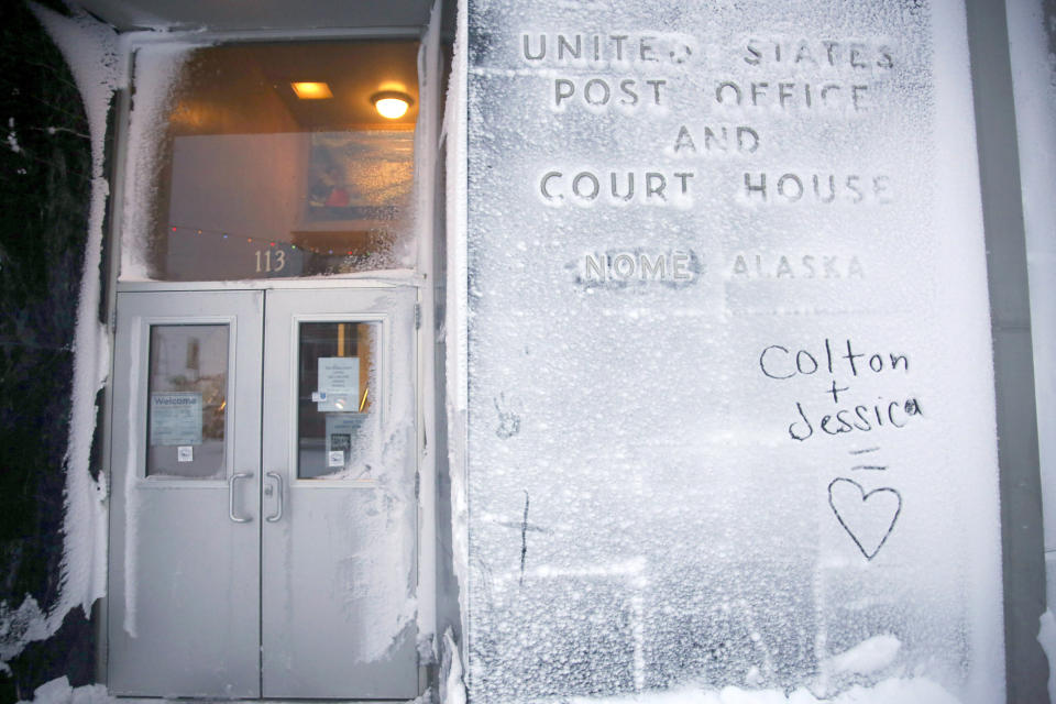 In this Feb. 13, 2019, photo, the names of two lovers are etched onto a snow covered wall of the United States Post Office and Court House in Nome, Alaska. (AP Photo/Wong Maye-E)