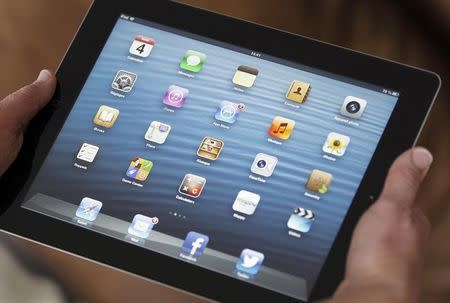 An illustration picture shows application icons on an Apple Ipad tablet held by a woman in Bordeaux, Southwestern France, February 4, 2013. REUTERS/Regis Duvignau