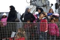 Refugees and migrants are seen aboard the Ayios Efstratios Coast Guard vessel following a rescue operation, at the port of the Greek island of Lesbos, February 8, 2016. REUTERS/Giorgos Moutafis