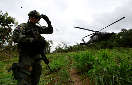 A Colombian anti-narcotics policeman taks position as he waits to board a helicopter in a rural area of Calamar in Guaviare state, Colombia, August 2, 2016. REUTERS/John Vizcaino