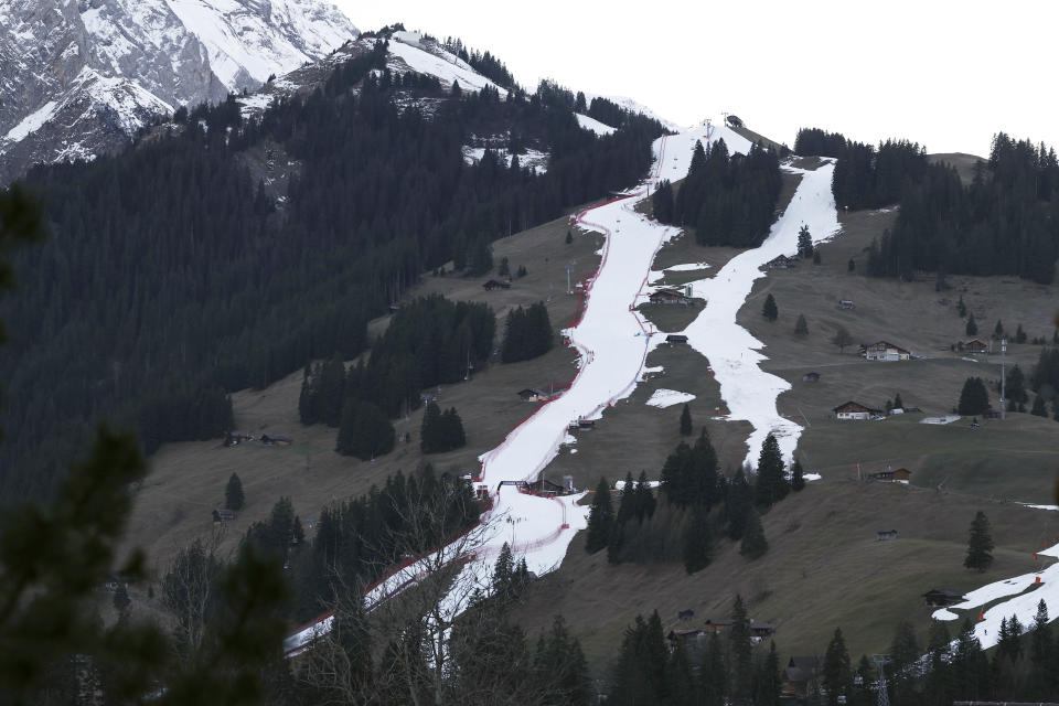 FILE - Thin strips of snow create the course, at left, of an alpine ski, men's World Cup giant slalom competition, in Adelboden, Switzerland, Friday, Jan. 6, 2023, the day before the race. Mother Nature and global warming are having just as much say about when and where to hold ski races these days as the International Ski Federation. (AP Photo/Gabriele Facciotti, File)
