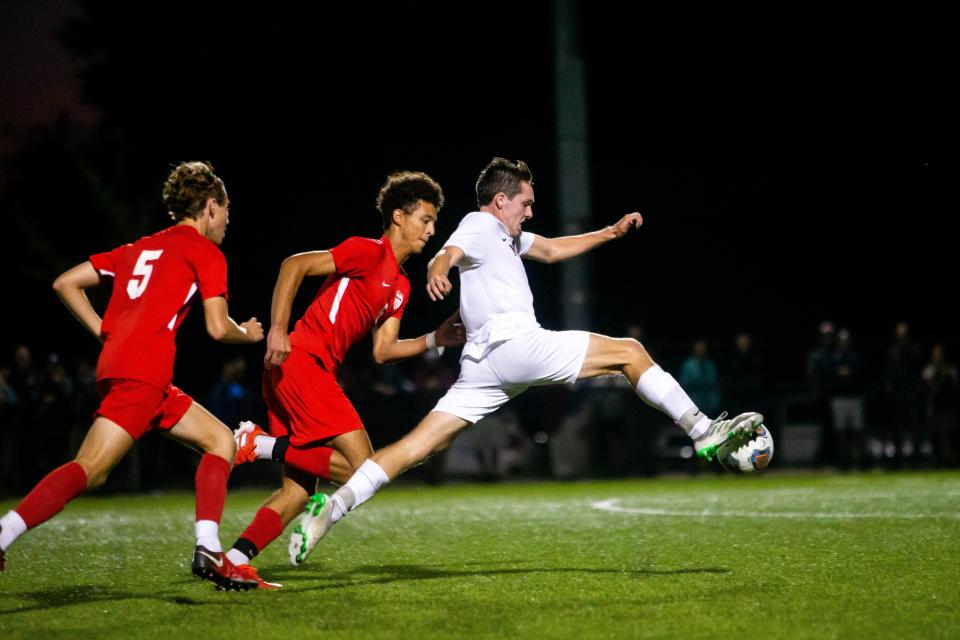 Holland Christian's Kirby Eggers gets the ball past the Holland defense Monday, Sept. 27, 2021, at Holland High School. 