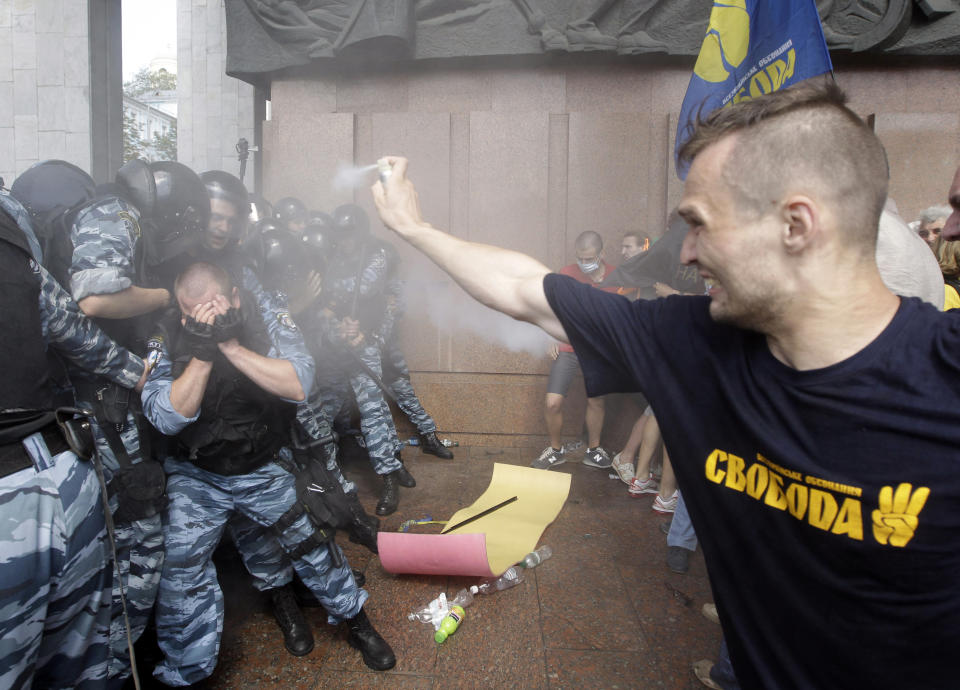 FILE - In this file photo taken on July 4, 2012, Dmytro Riznychenko sprays tear gas at riot police in central Kyiv, Ukraine, as part of protests against a controversial bill that would allow the use of the Russian language in official settings in Russian-speaking regions. On Nov. 21, 2023, Ukraine marks the 10th anniversary of the mass protests in Ukraine that eventually led to the ouster of Ukraine’s Moscow-friendly president. (AP Photo/Efrem Lukatsky, file)