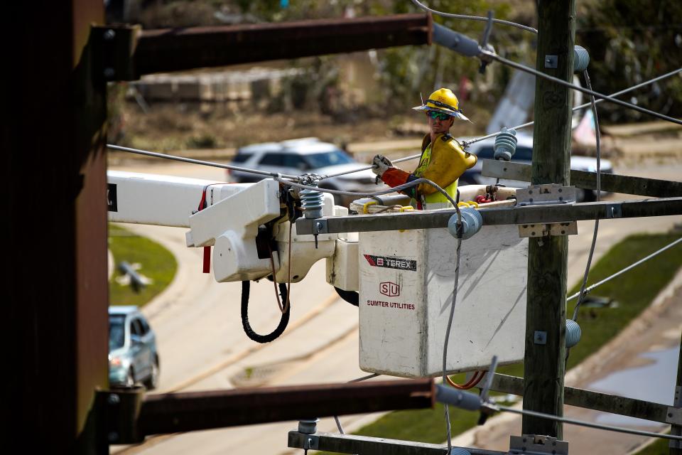 Workers repair power lines in the River Arts District in Asheville, N.C., Monday, Sept. 30, 2024. Many parts of Asheville remain without power as a result of Hurricane Helene.