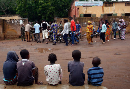 People stand in line as they wait outside a polling station before the polls open during a presidential run-off election in Bamako, Mali August 12, 2018. REUTERS/Luc Gnago