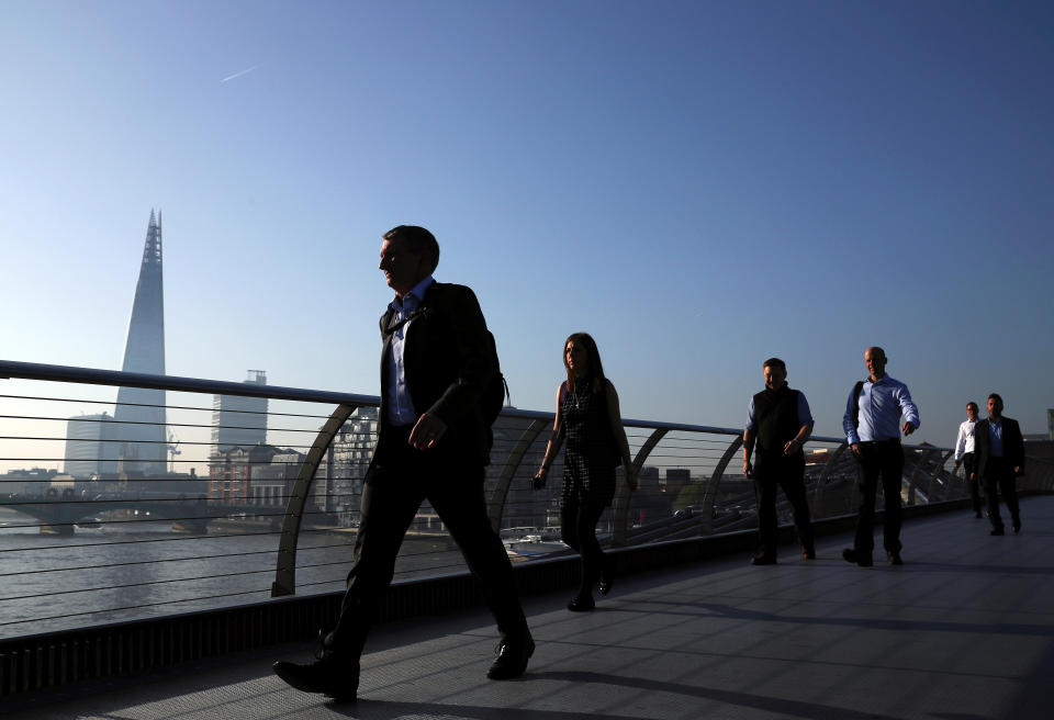 People cross the Millenium Bridge in front of the Shard on a sunny morning in London, Britain, May 8, 2018. REUTERS/Hannah McKay