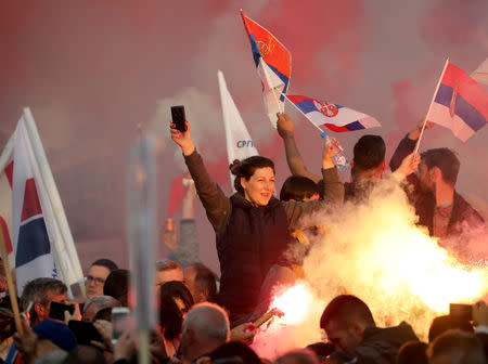 Supporters of Serbian President Aleksandar Vucic burn flare as they wait for his arrival for his campaign rally "The Future of Serbia" in front of the Parliament Building in Belgrade, Serbia, April 19, 2019. REUTERS/Marko Djurica