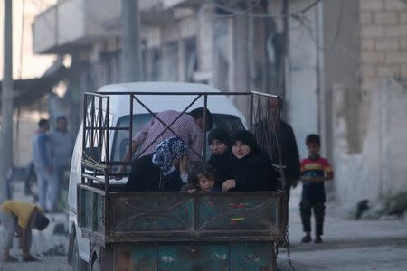 Reisidents ride on the back of a pick-up truck in Manbij, in Aleppo Governorate, Syria, August 9, 2016. REUTERS/Rodi Said