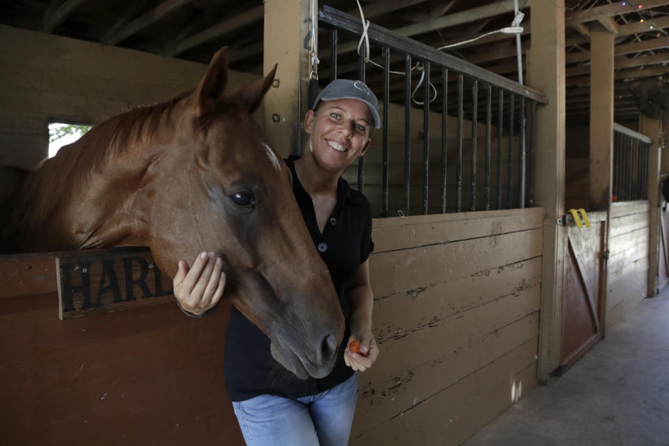 Timea Hunter poses for a photograph at the Family Horse Academy, where she is hoping to organize education for a group of children during the coronavirus pandemic, Friday, July 31, 2020, in Southwest Ranches, Fla. Confronting the likelihood of more distance learning, families across the country are turning to private tutors and "learning pods" to ensure their children receive some in-person instruction. The arrangements raise thorny questions about student safety, quality assurance, and inequality. (AP Photo/Lynne Sladky)