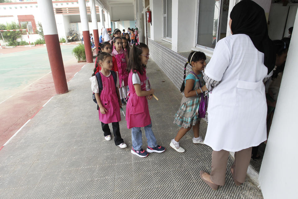 FILE - Schoolchildren enter a class in the Ben Omar district of Algiers, Algeria, on Sept. 19, 2023. More than a year after Algeria launched a pilot program to teach English in elementary schools, the country is hailing it as a success and expanding it in a move that reflects a widening linguistic shift underway in former French colonies throughout Africa. (AP Photo, File)