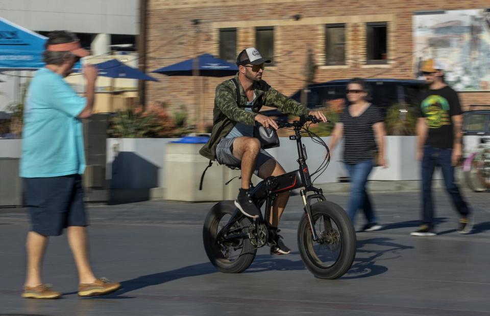 A man rides his e-bike on the Strand in Hermosa Beach. In Hermosa Beach, it's against city code to use electric