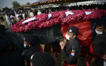 FILE - In this July 30, 2021 file photo, Police officers carry a casket of their colleague, who was killed in a grenade attack, during a funeral prayer, in Peshawar, Pakistan. The Taliban win in Afghanistan is giving a boost to militants in neighboring Pakistan. The Pakistani Taliban, known as the TTP, have become emboldened in tribal areas along the border with Afghanistan. (AP Photo/Muhammad Sajjad, File)