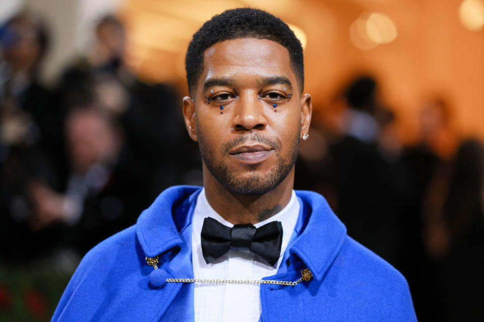 Kid Cudi wearing face jewelry and a bright-colored tux