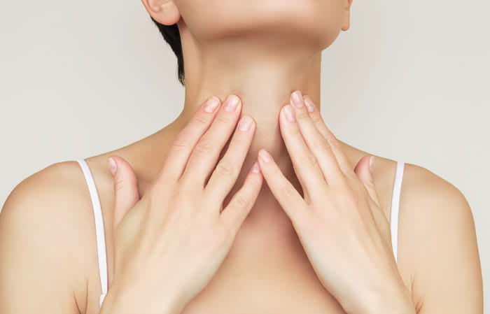 mujer palpando su cuello