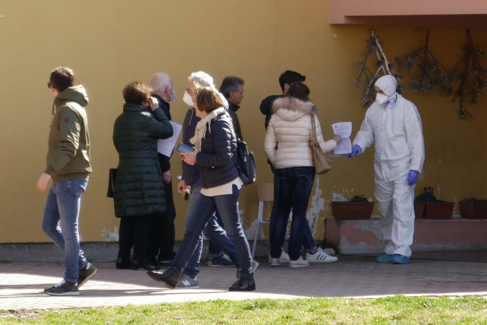 People line up to undergo a voluntary test of Coronavirus, part of a study of the University of Padua, in Vo' Euganeo, a town of 3,500 people at the epicenter of the Veneto cluster, which was sealed off until Sunday, March 8, 2020. Italy announced a sweeping quarantine early Sunday for its northern regions, igniting travel chaos as it restricted the movements of a quarter of its population in a bid to halt the new coronavirus' relentless march across Europe. (AP Photo/Andrea Casalis)