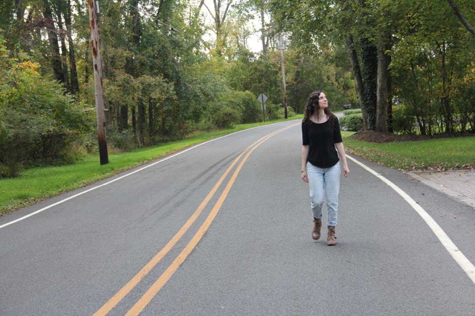 A woman walking on a road.