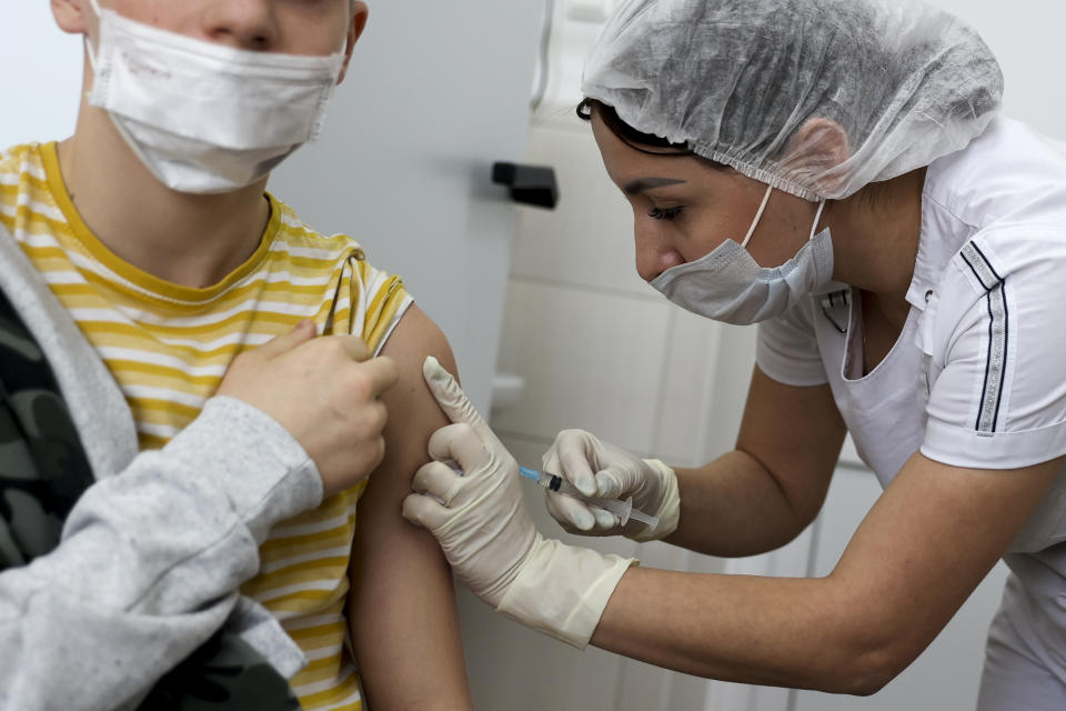 A teenager receives a dose of Russia's Sputnik M (Gam-COVID-Vac-M) COVID-19 vaccine in Krasnodar, Russia, Friday, Jan. 28, 2022. This week, Russia started vaccinating children aged 12-17 with a domestically developed shot, Spuntik M — a version of the Sputnik V vaccine that contains a smaller dose — amid reports of a sharp spike of COVID-19 infections and hospitalization in children. (AP Photo/Vitaliy Timkiv)