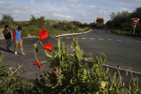 Two migrants walk on a road near the city limits in Calais, France May 18, 2015 after they travelled northwards in the hopes of crossing the English Channel on lorries and seeking asylum in Britain. REUTERS/Pascal Rossignol