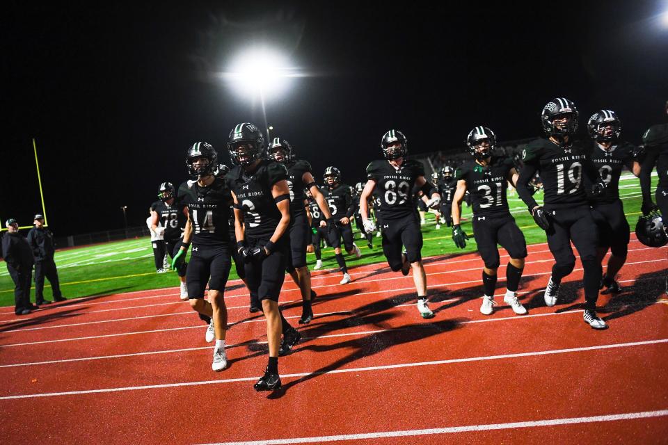 Fossil Ridge players run to celebrate with the student section after winning a high school football game against Windsor at PSD Stadium in Timnath on Thursday. The SaberCats won 35-30.