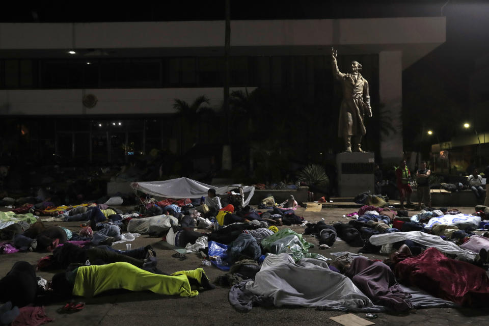 Honduran migrants hoping to reach the U.S. sleep in the southern Mexico city of Tapachula, on Monday, Oct. 22, 2018, in a public plaza featuring a statue of Mexican national hero Miguel Hidalgo, a priest who launched Mexico's War of Independence in 1810. Towns suddenly receiving thousands of people bedding down in overflowing plazas and parks are organizing to offer them shelter, medical treatment and donations as best they can.(AP Photo/Moises Castillo)