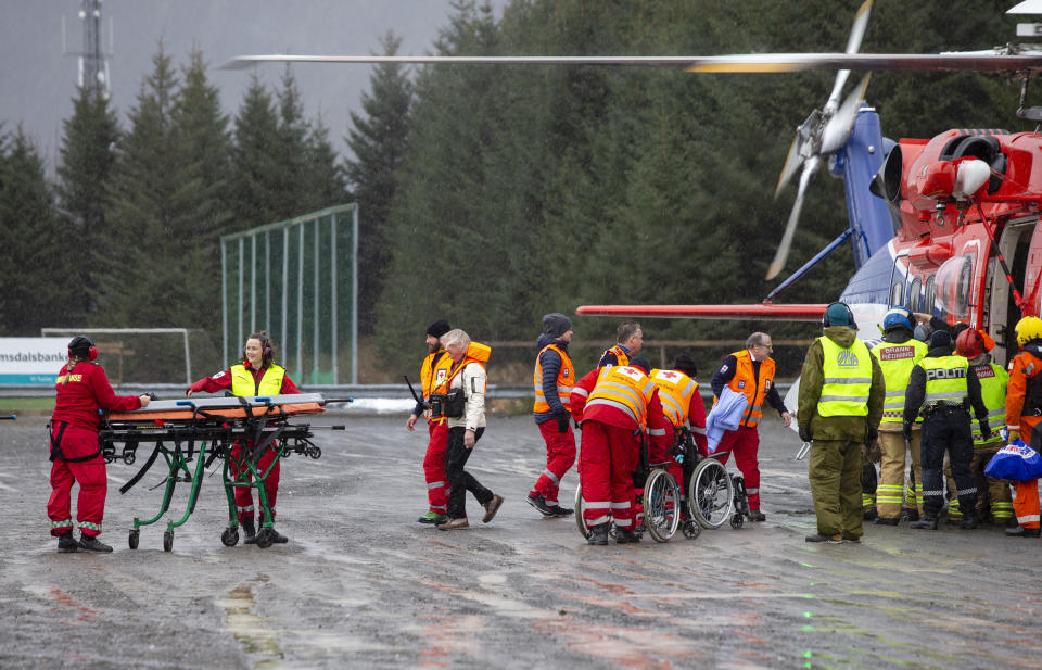 Passengers are helped from a rescue helicopter in Fraena, Norway, Sunday March 24, 2019, after being rescued from the Viking Sky cruise ship. Rescue workers are evacuating more passengers from a cruise ship that had engine problems in bad weather off Norway's western coast while authorities prepare to tow the vessel to a nearby port. (Svein Ove Ekornesvag/NTB Scanpix via AP)