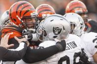 Andrew Whitworth #77 of the Cincinnati Bengals fights with Lamaar Houston #99 of the Oakland Raiders during their game at Paul Brown Stadium on November 25, 2012 in Cincinnati, Ohio. The Bengals defeated the Raiders 34-10. (Photo by John Grieshop/Getty Images)