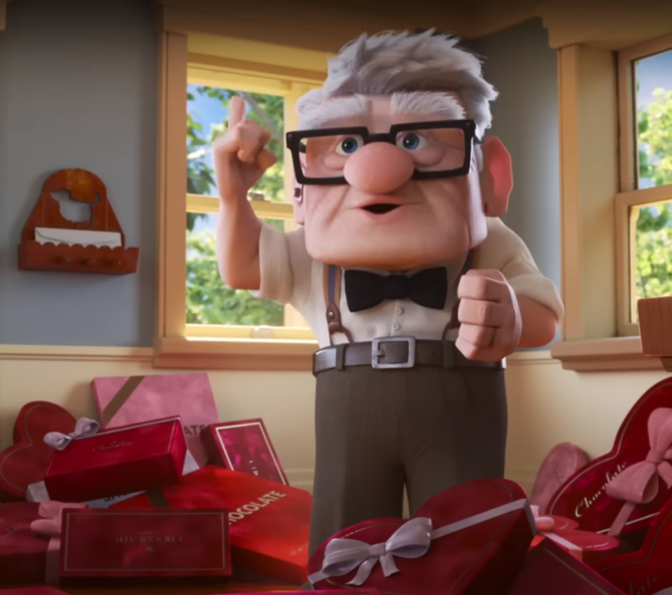 carl from up looking excited surrounded by red boxes of chocolate heart shapes