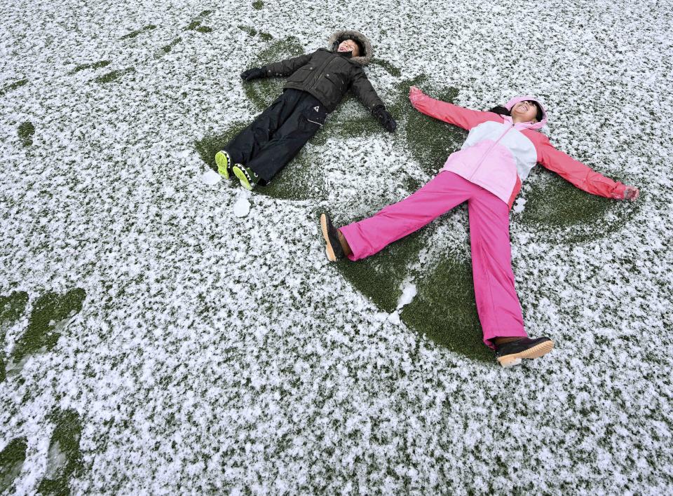 Jacob Polanco, left, 8, and his older sister Khloe, 9, make snow angels in Rancho Cucamonga, Calif., on Saturday, Feb. 25, 2023.  (Will Lester / The Orange County Register via AP)