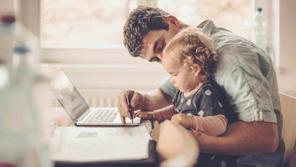 Fahter is showing his daughter things on a laptop.