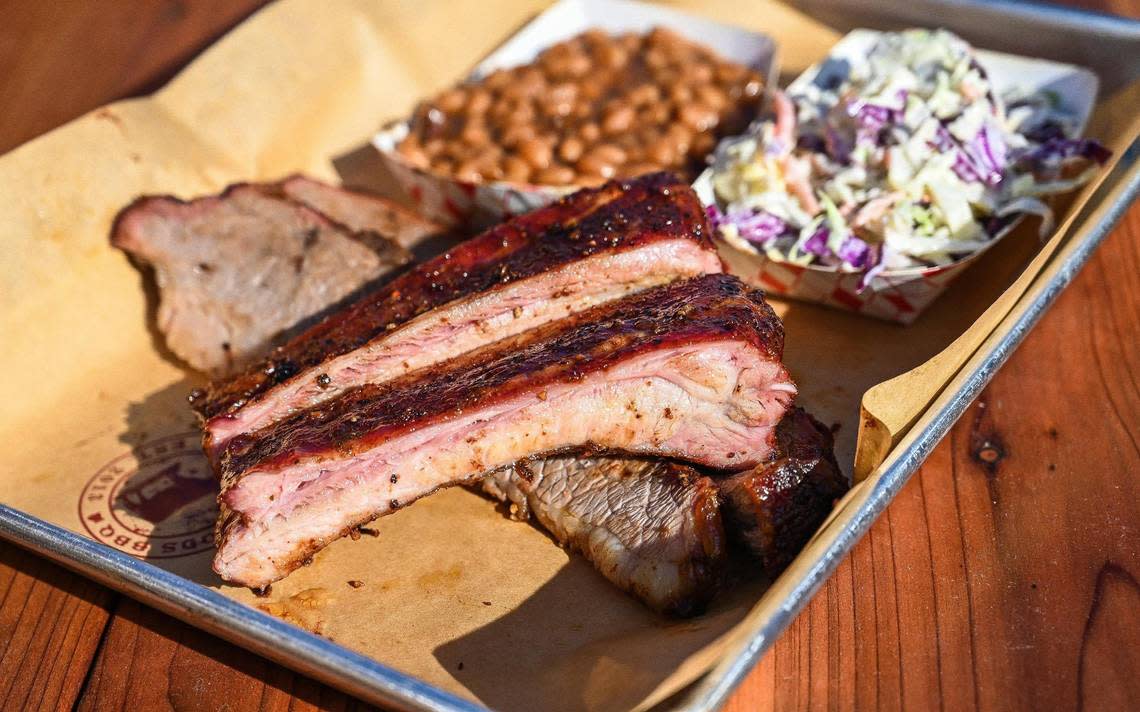 A plate of smoked barbecue ribs, brisket and sides at Smoking Woods food truck in Fresno’s Brewery District in downtown Fresno on Friday, Dec. 9, 2022.