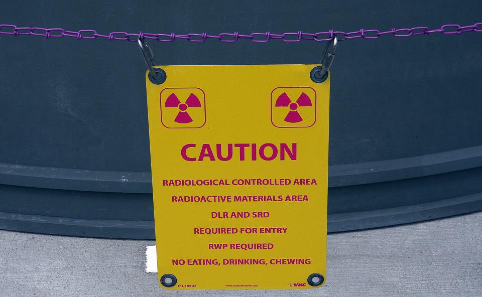A radioactive warning sign in front of spent fuel storage casks at the Pilgrim Nuclear Power Station in May of 2015 Times photograph.