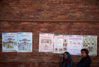 Women stand along the instruction posters displayed by the Election Commission near the polling station, a day ahead of the parliamentary and provincial elections in Kathmandu, Nepal December 6, 2017. REUTERS/Navesh Chitrakar