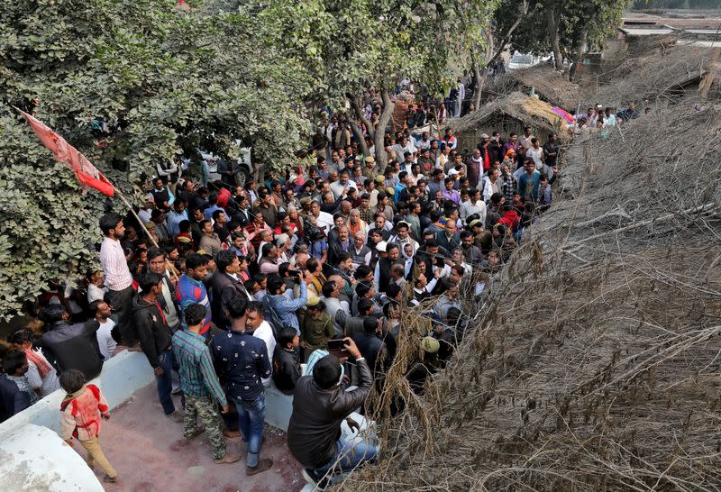 La gente se reúne frente a la casa de la víctima de violación de 23 años de edad, que murió en un hospital de Nueva Delhi el viernes después de que una banda de hombres, entre ellos sus presuntos violadores, la prendiera fuego en Unnao