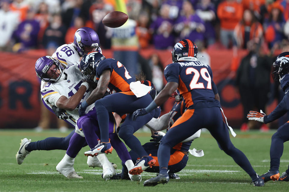 DENVER, COLORADO - NOVEMBER 19: Quarterback Joshua Dobbs #15 of the Minnesota Vikings fumbles the football after being hit by safety Kareem Jackson #22 of the Denver Broncos during the first quarter of the NFL game at Empower Field At Mile High on November 19, 2023 in Denver, Colorado. (Photo by Matthew Stockman/Getty Images)