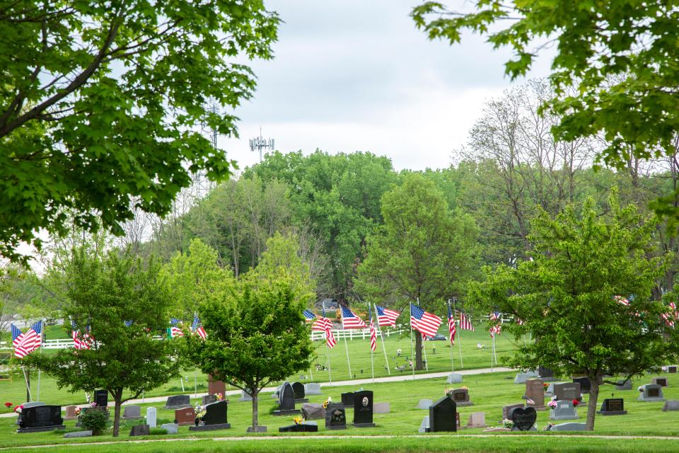 American flags line the road through Oak Hill Cemetery prior to Memorial Day during the novel coronavirus, COVID-19, pandemic, Friday, May 22, 2020, in Coralville, Iowa.