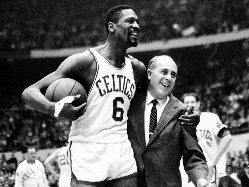 Bill Russell, left,  is congratulated by coach Red Auerbach after scoring his 10,000th career point.