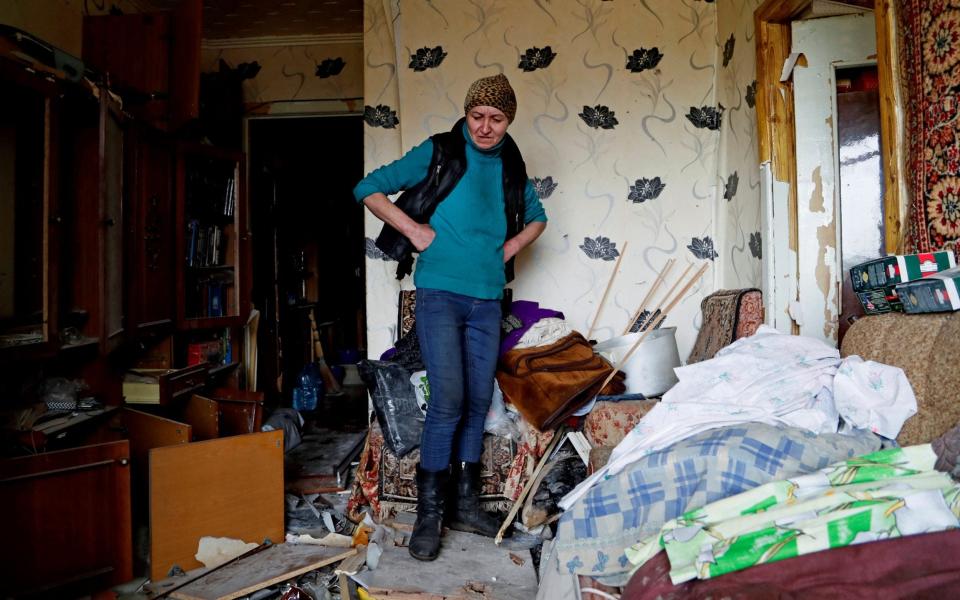 Natalia Kovalenko, 52, stands inside her damaged apartment in the town of Popasna in the Luhansk Region - REUTERS/Alexander Ermochenko