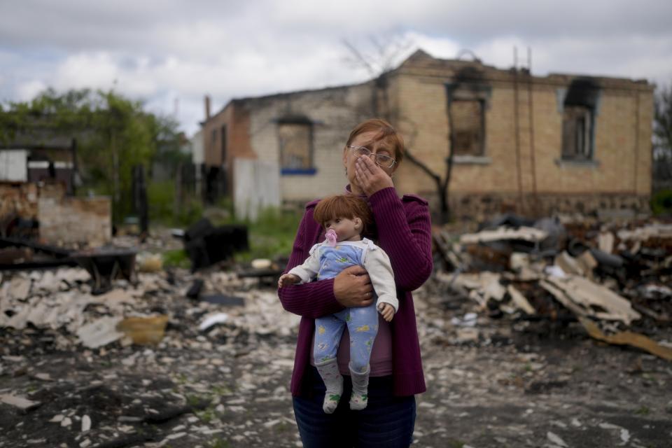 FILE - Nila Zelinska holds a doll belonging to her granddaughter, she was able to find in her destroyed house in Potashnya, Ukraine, Tuesday, May 31, 2022. War has been a catastrophe for Ukraine and a crisis for the globe. One year on, thousands of civilians are dead, and countless buildings have been destroyed. Hundreds of thousands of troops have been killed or wounded on each side. Beyond Ukraine’s borders, the invasion shattered European security, redrew nations’ relations with one another and frayed a tightly woven global economy. (AP Photo/Natacha Pisarenko, File)