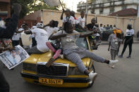 Supporters of the Gambian President Adama Barrow celebrate the partial results that give the lead to their candidate during the counting ballots in Gambia's presidential election, in Banjul, Gambia, Sunday, Dec. 5, 2021. Election officials in the West African nation of Gambia have started counting marble votes after polls closed for the first presidential election in decades that does not include former dictator Yahya Jammeh as a candidate. (AP Photo/Leo Correa)