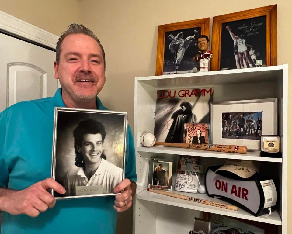 Brian Kelly, a former Alliance, Canton and Akron radio DJ in the 1980s and '90s, is shown with an old photo of himself at his home studio in Jackson Township. Kelly is now an on-air personality for the internet-based CTown Rocks radio station in Canton.