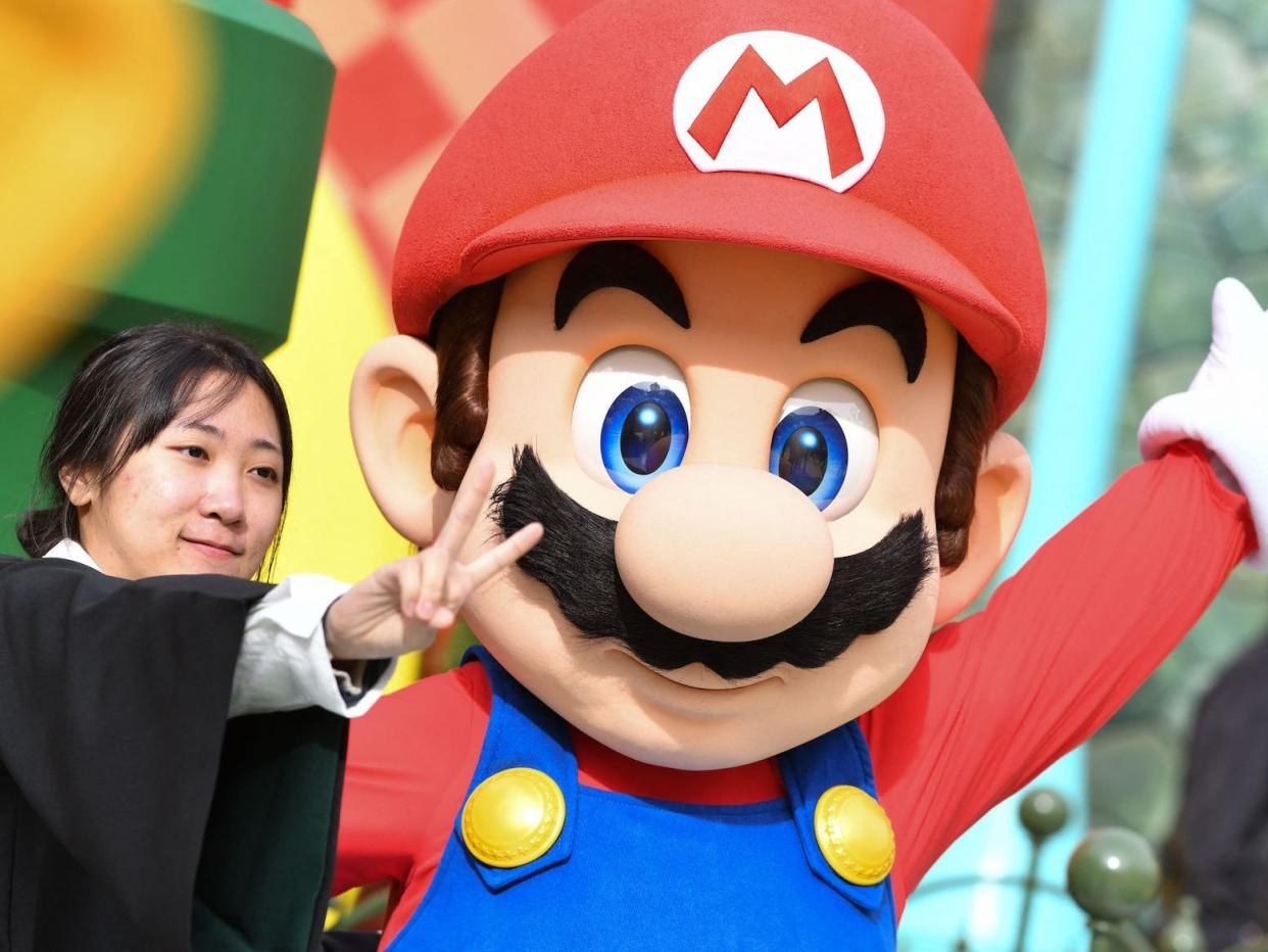 A guest takes a photo with Mario during a preview of Super Nintendo World at Universal Studios in Los Angeles, California, on January 13, 2023. -